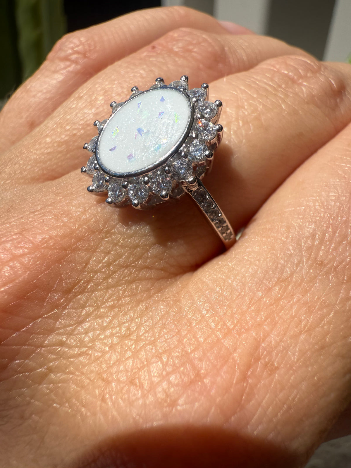 Sterling silver oval breastmilk ring with a halo of crystal gemstones
