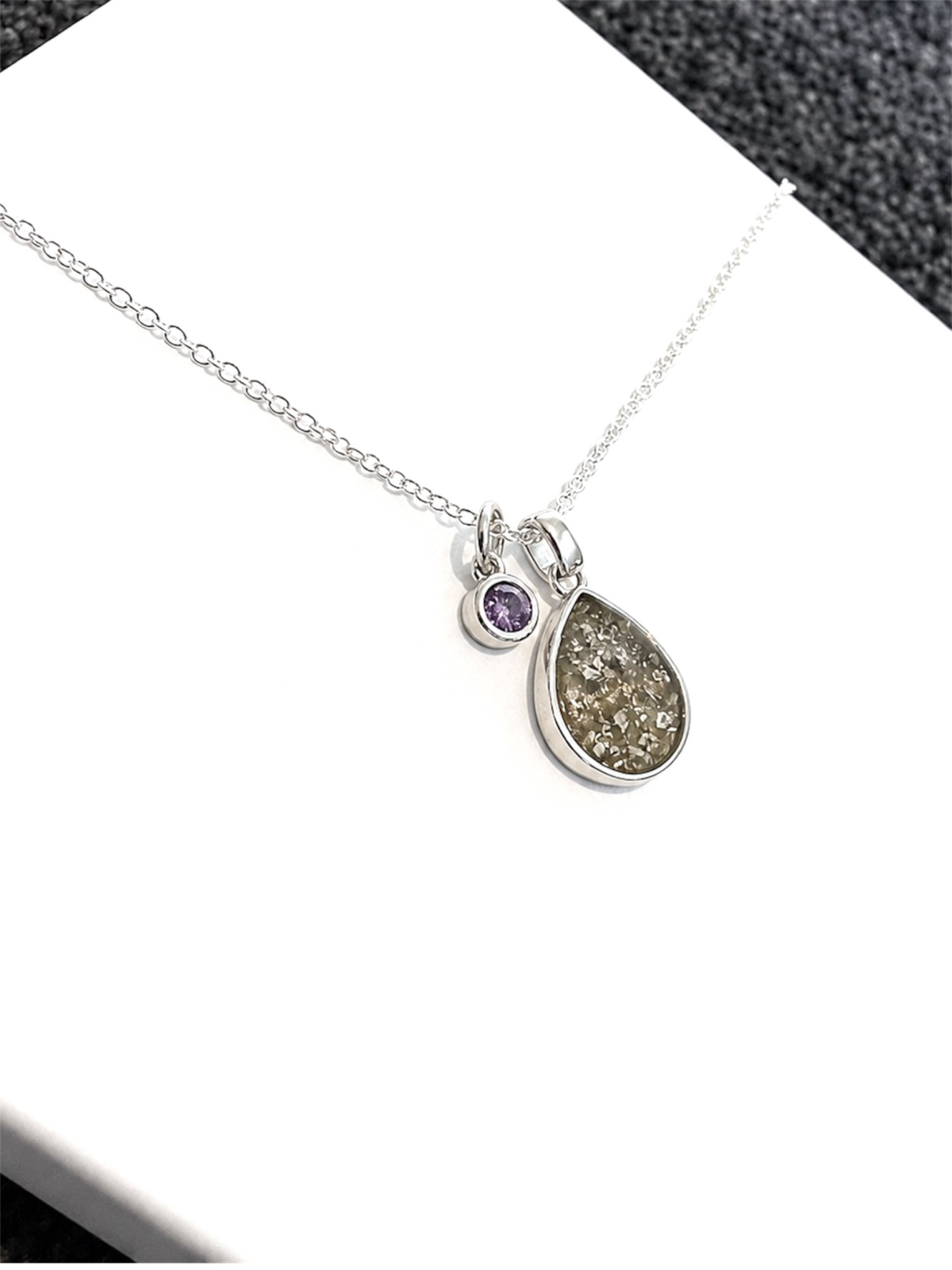 Memorial necklace containing cremation ashes as a precious keepsake.