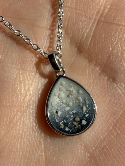 Teardrop-shaped pendant holding a loved one’s cremation ashes. 
