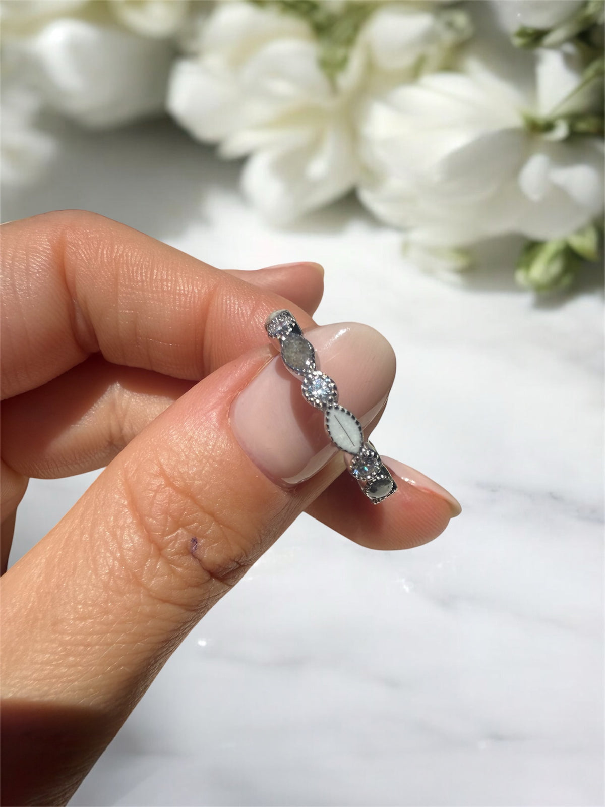 Ring containing ashes and hair in sterling silver with clear cubic zirconia gemstones.