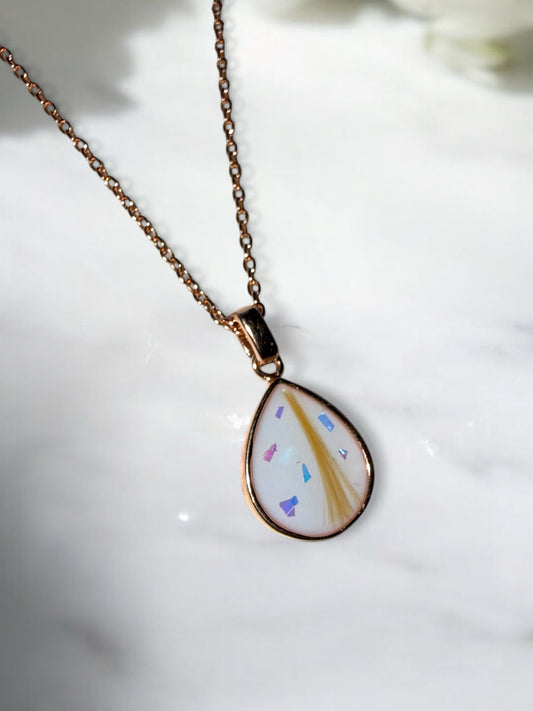 Breastmilk keepsake necklace containing preserved breastmilk and a lock of hair