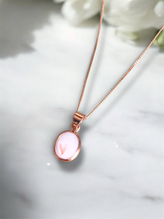 Rose gold breastmilk keepsake necklace containing preserved breastmilk and wedding flowers