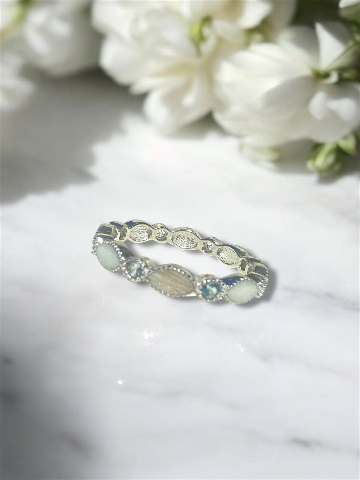 A sterling silver ring containing hair and preserved breastmilk. 